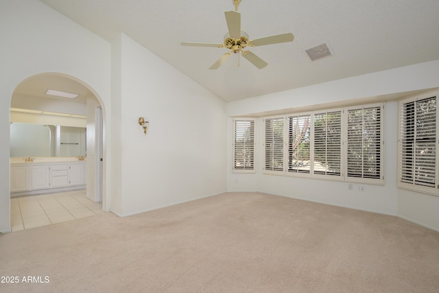 carpeted empty room with ceiling fan, high vaulted ceiling, and sink