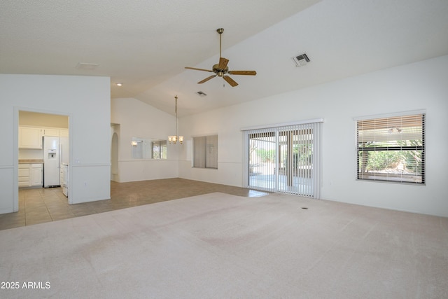 unfurnished living room with ceiling fan with notable chandelier, light carpet, and high vaulted ceiling