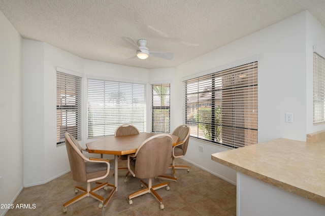 dining room featuring ceiling fan, tile patterned flooring, and a textured ceiling