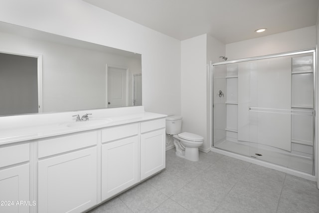 bathroom with tile patterned flooring, vanity, toilet, and a shower with door