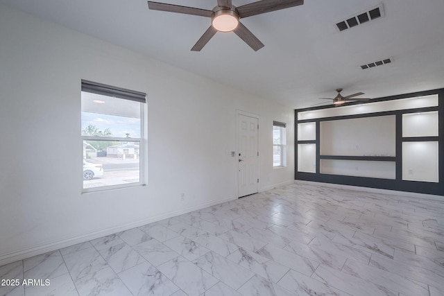 unfurnished room featuring visible vents, a ceiling fan, and marble finish floor