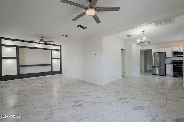 spare room featuring marble finish floor, visible vents, and ceiling fan with notable chandelier