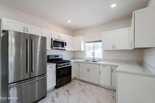 kitchen with marble finish floor, light countertops, white cabinetry, a sink, and stainless steel appliances