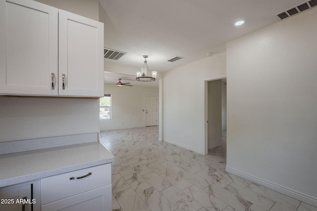 interior space featuring light countertops, white cabinets, a chandelier, and visible vents