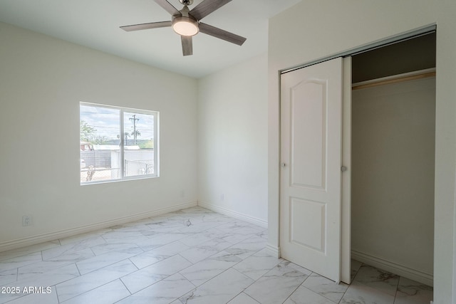 unfurnished bedroom with a ceiling fan, baseboards, marble finish floor, and a closet