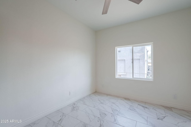 unfurnished room with ceiling fan, baseboards, and marble finish floor
