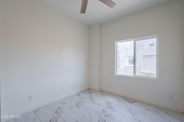 unfurnished room featuring baseboards, marble finish floor, and ceiling fan