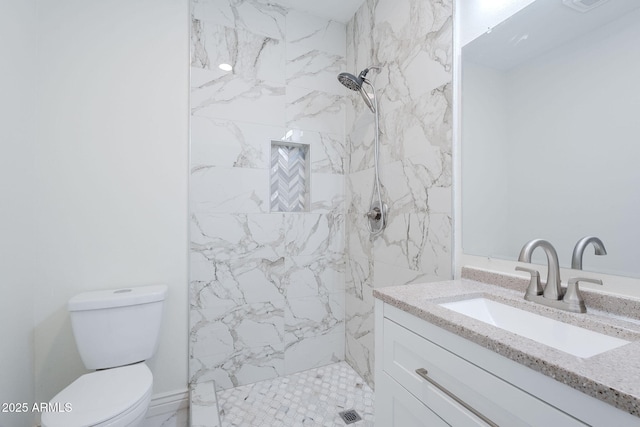 bathroom with toilet, a marble finish shower, and vanity