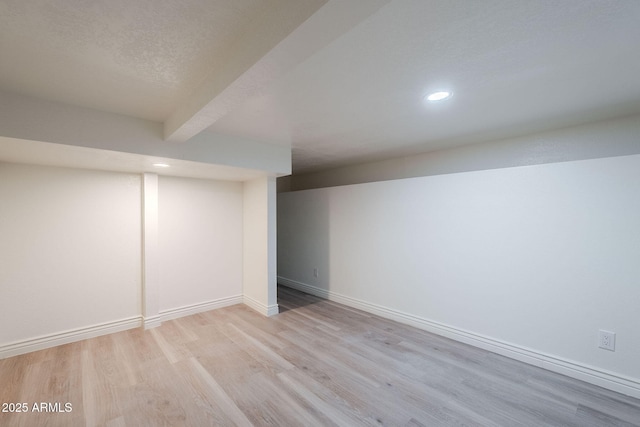 finished below grade area featuring recessed lighting, baseboards, and wood finished floors