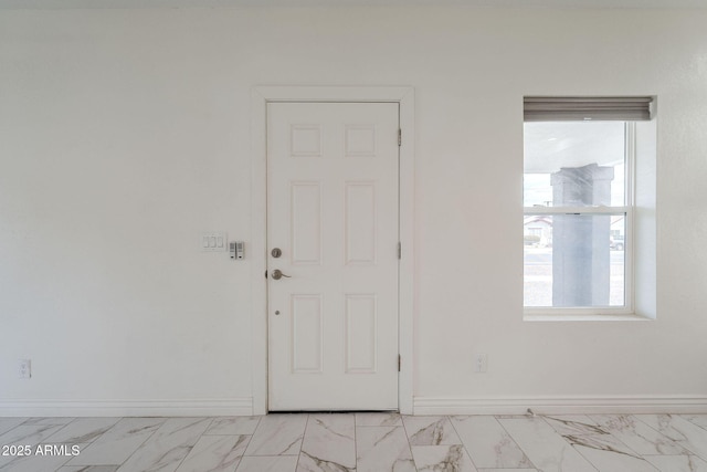 interior space featuring baseboards and marble finish floor