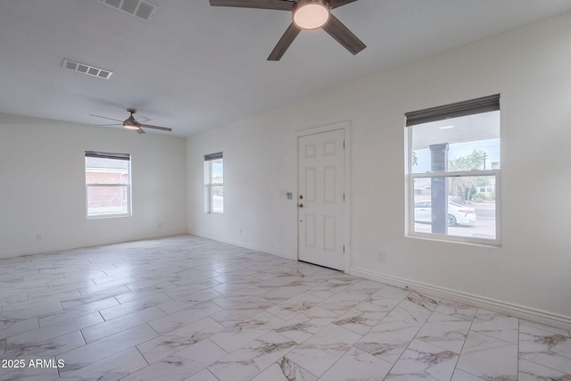 spare room with visible vents, a ceiling fan, marble finish floor, and baseboards