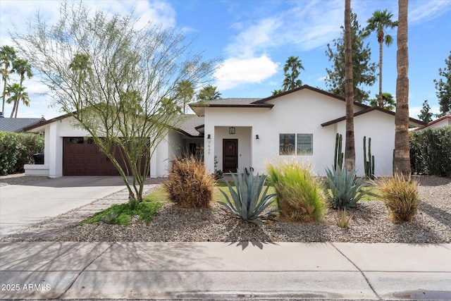 view of front of house featuring an attached garage, driveway, and stucco siding