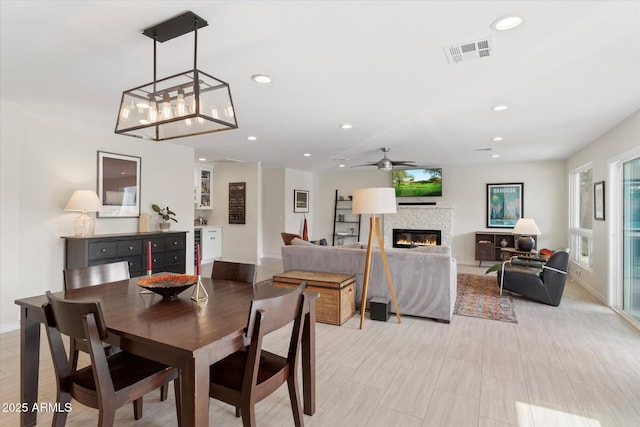 dining room featuring recessed lighting, visible vents, a glass covered fireplace, and ceiling fan