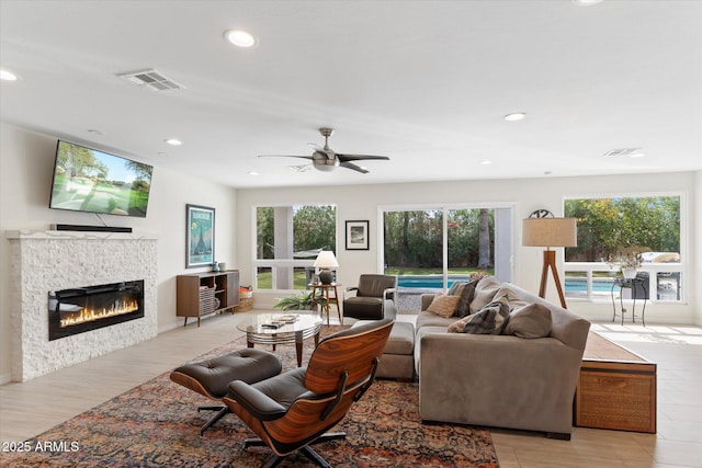 living room featuring visible vents, a healthy amount of sunlight, and a fireplace