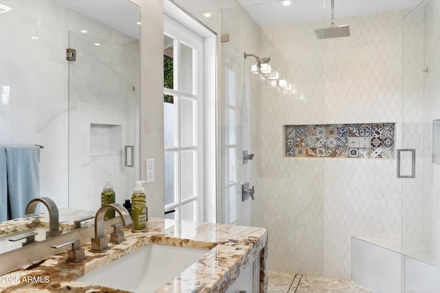 bathroom with a shower stall, tile walls, and vanity