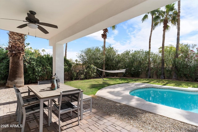 outdoor pool featuring outdoor dining space, a fenced backyard, ceiling fan, a patio area, and a lawn