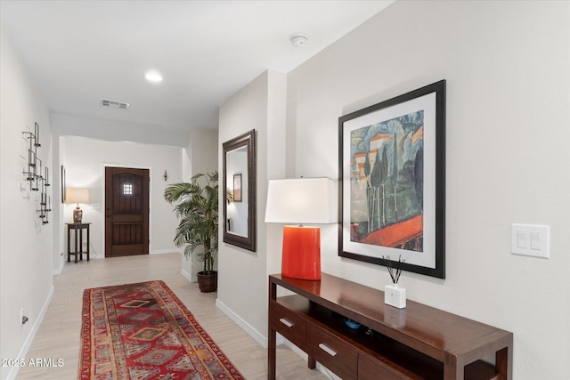 hall featuring recessed lighting, light wood-style floors, visible vents, and baseboards