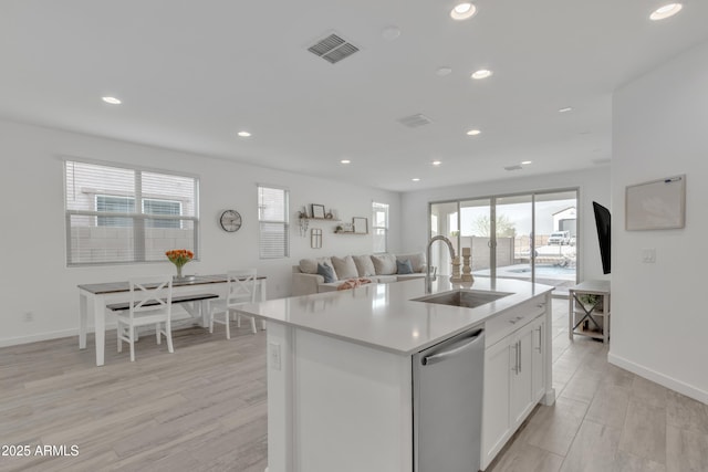 kitchen with visible vents, white cabinets, dishwasher, light countertops, and a sink