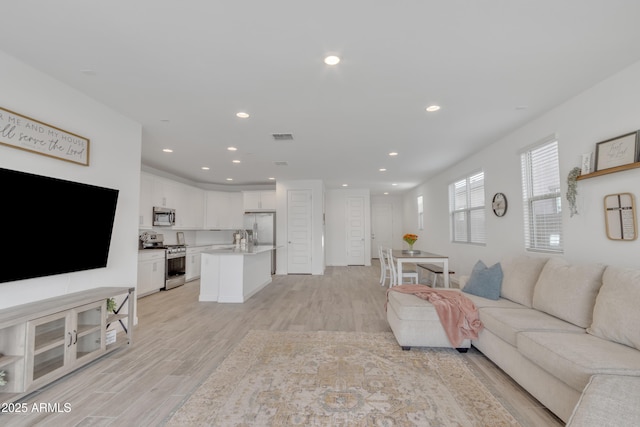 living area featuring recessed lighting, visible vents, and light wood-style flooring