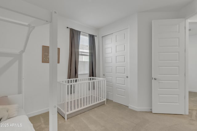 carpeted bedroom featuring a closet and baseboards