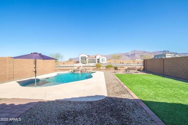 view of swimming pool featuring a fenced in pool, a lawn, a fenced backyard, a patio area, and a mountain view