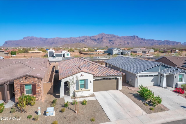 view of front of house featuring stucco siding, concrete driveway, a mountain view, a garage, and a tiled roof