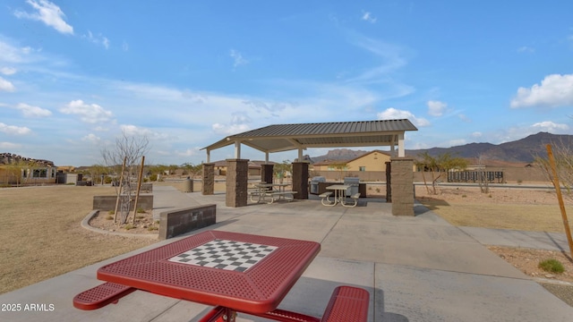 view of patio featuring a gazebo, fence, and a mountain view