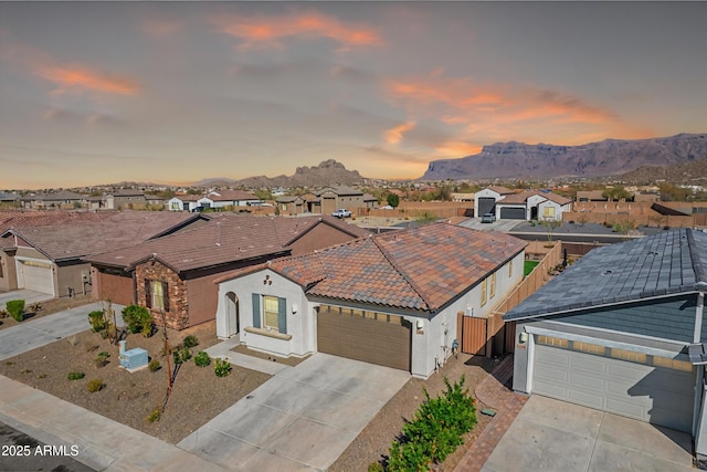 view of front of house with a garage, driveway, a mountain view, and a residential view