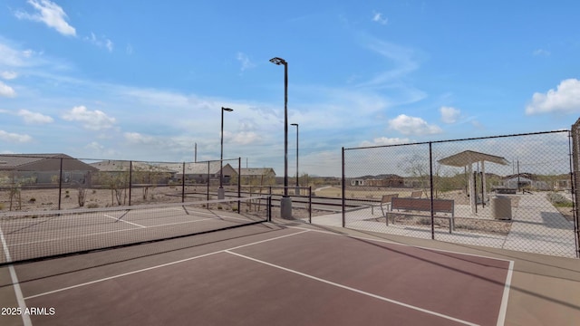 view of tennis court featuring fence