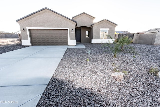 ranch-style home with concrete driveway, an attached garage, a tile roof, and stucco siding