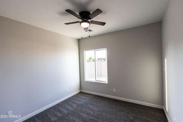 spare room with visible vents, dark carpet, a ceiling fan, and baseboards