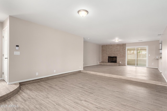 9803 N 40th Dr, Phoenix, AZ 85051 - unfurnished living room featuring light wood-style floors, baseboards, and a brick fireplace