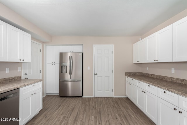 9803 N 40th Dr, Phoenix, AZ 85051 - kitchen with appliances with stainless steel finishes, light wood-style flooring, white cabinets, and baseboards