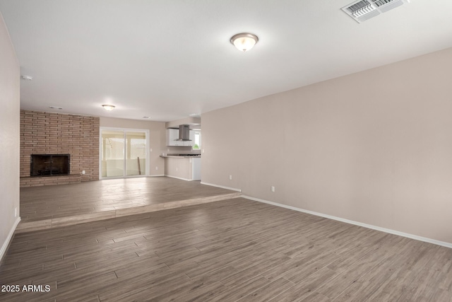 9803 N 40th Dr, Phoenix, AZ 85051 - unfurnished living room featuring wood finished floors, baseboards, and a fireplace