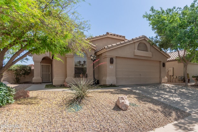 43803 W Wade Dr, Maricopa, AZ 85138 - mediterranean / spanish-style home featuring a garage, driveway, stucco siding, and a tiled roof
