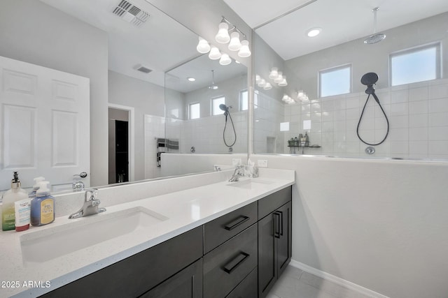 bathroom featuring vanity, tile patterned floors, and a tile shower