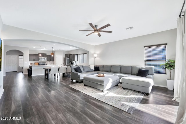 living room featuring ceiling fan and dark hardwood / wood-style floors