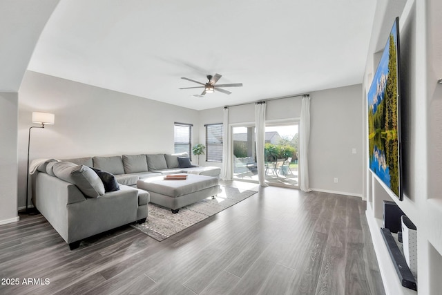 living room featuring ceiling fan and dark hardwood / wood-style floors