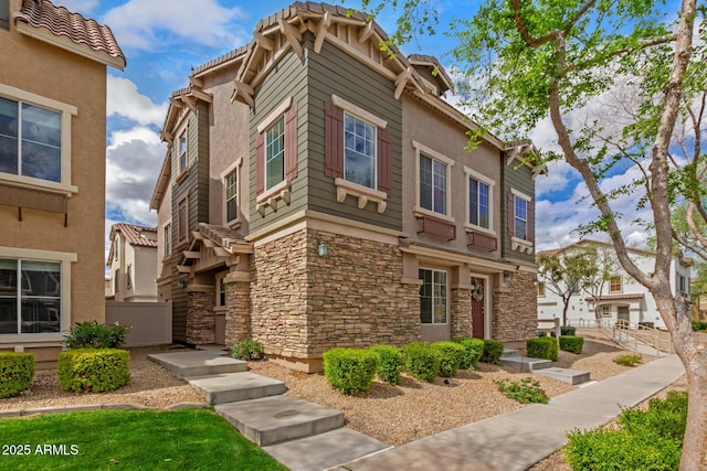 exterior space with stone siding, stucco siding, and fence