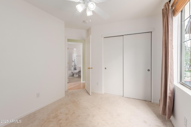 unfurnished bedroom featuring a closet, multiple windows, and light colored carpet