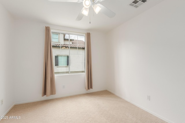 empty room with visible vents, light colored carpet, baseboards, and ceiling fan