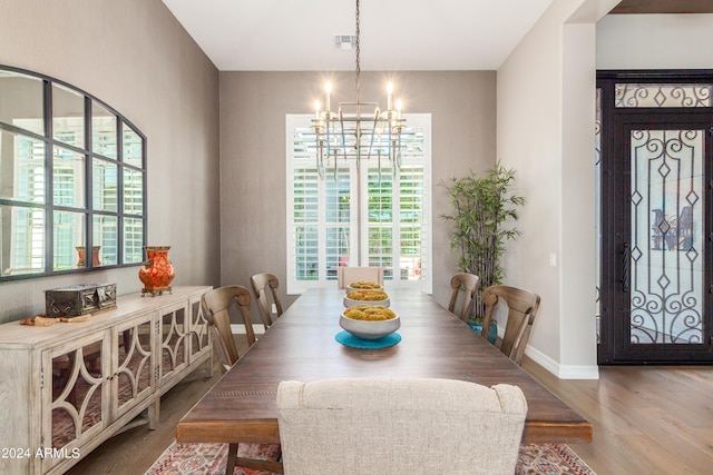 dining room with a notable chandelier, a wealth of natural light, and light hardwood / wood-style flooring