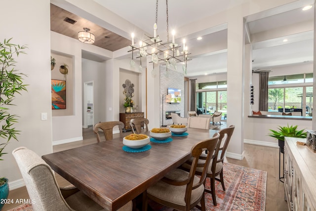 dining room with an inviting chandelier, light hardwood / wood-style flooring, and wood ceiling