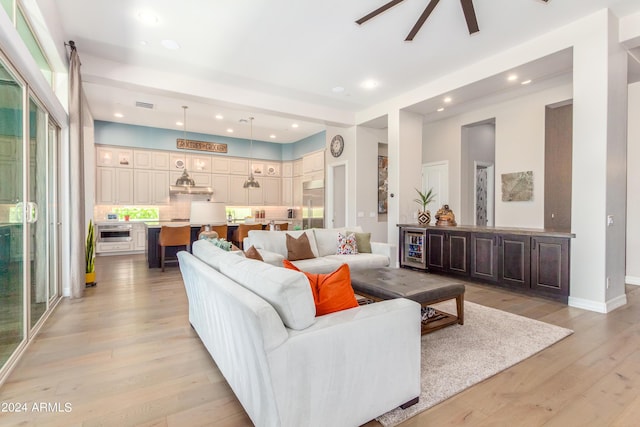 living room with ceiling fan and light hardwood / wood-style floors