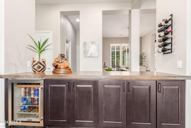 bar featuring dark brown cabinetry and beverage cooler