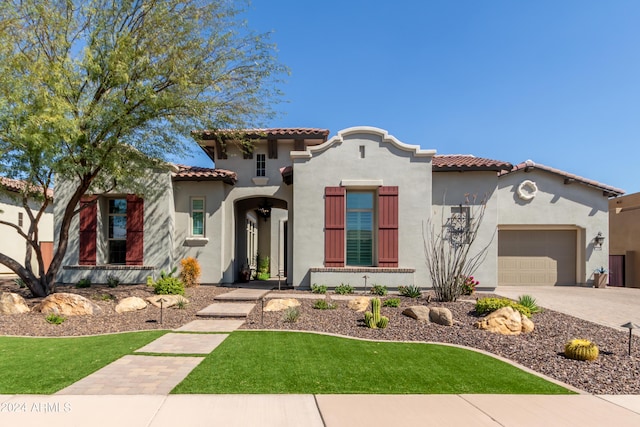 mediterranean / spanish-style house with a front yard and a garage