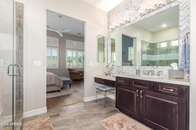 bathroom with ceiling fan, a shower with door, backsplash, and vanity