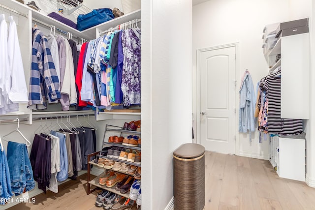 walk in closet with light hardwood / wood-style flooring