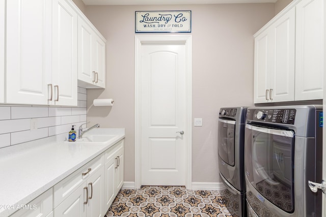 washroom featuring washer and clothes dryer, cabinets, light tile patterned floors, and sink