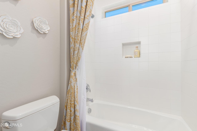 bathroom featuring shower / bathtub combination with curtain and toilet